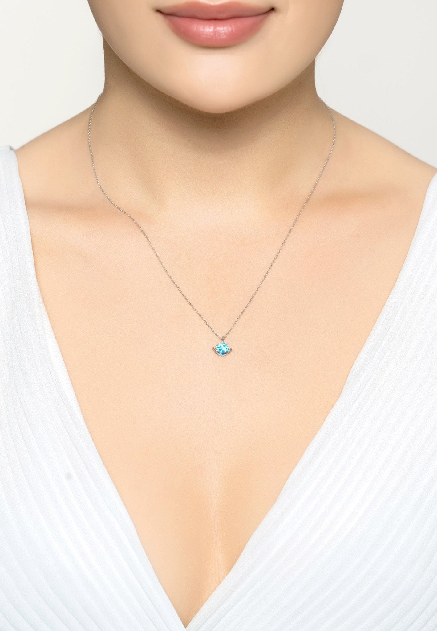 Necklace with a blue heart pendant worn by a model.