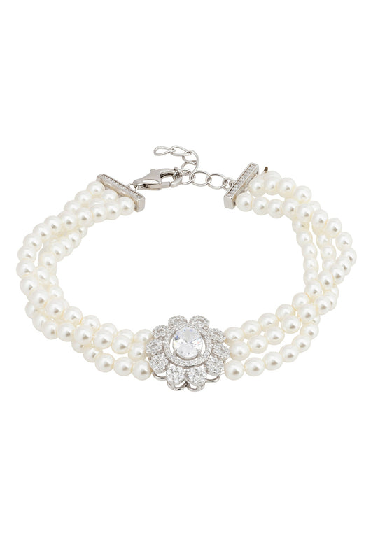 A silver-plated pearl strand bracelet with a floral motif centerpiece and sparkling stones.