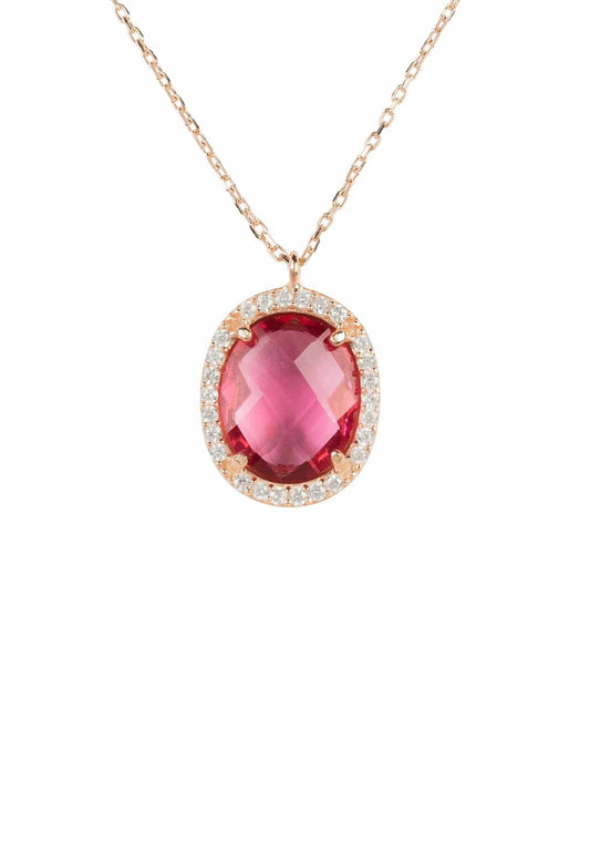 An oval pendant necklace with a pink tourmaline gemstone and a halo of smaller cubic zirconia set in rose gold.